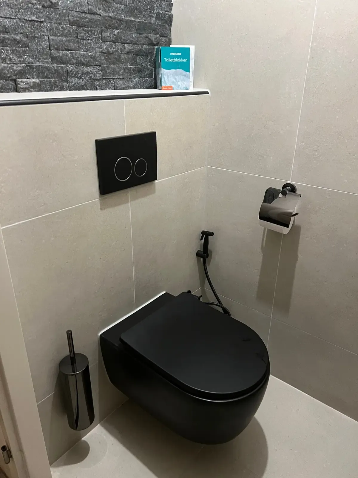 Toilet met mat zwart hangtoilet en lichte tegels